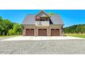 Spacious three-car garage with an upper balcony and beautiful curb appeal, perfect for car enthusiasts at 2258 Sanders Rd, Stem, NC 27581
