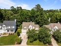 Aerial view of a suburban home surrounded by lush green trees in a quiet neighborhood at 2412 Colony Woods Dr, Apex, NC 27523