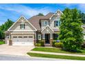 Attractive home with a well-kept lawn, and inviting front porch, complemented by mature trees at 2538 Tuffeto, Apex, NC 27502