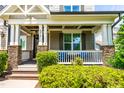 Cozy front porch with stone pillars, comfortable seating, manicured landscaping, and inviting charm at 2538 Tuffeto, Apex, NC 27502
