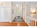 Open foyer with hardwood floors, staircase, coat closet, and a view of the front door at 2606 Sherbrooke Dr, Durham, NC 27712