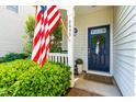 Inviting front door with a wreath and an American flag, surrounded by lush green bushes at 2635 Asher View Ct, Raleigh, NC 27606