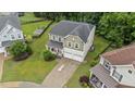 Aerial view of home with a manicured lawn, two-car garage, and mature trees at 2709 Banks Lake Ct, Fuquay Varina, NC 27526