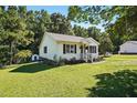 Well-maintained one-story home with black shutters, green lawn, and landscaping at 364 Chinaberry Ln, Angier, NC 27501
