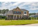 Attractive brick home featuring black shutters, a covered porch, and a landscaped front yard at 367 Tayside St, Clayton, NC 27520
