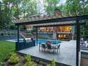 Outdoor kitchen and dining area featuring a grill, dining table with seating, and beautiful backyard at 3910 Somerset Dr, Durham, NC 27707