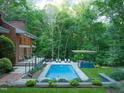 Beautiful backyard oasis with a sparkling pool, outdoor seating, and lush greenery for ultimate relaxation at 3910 Somerset Dr, Durham, NC 27707