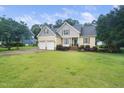 Charming two-story home with a well-manicured lawn and attached two-car garage in a lush green neighborhood at 3916 Rustic Mill Dr, Apex, NC 27539