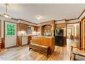 Cozy kitchen featuring wood cabinets, a brick cooking area, stainless steel appliances, and wood flooring at 4272 Boyd Wright Rd, Burlington, NC 27215