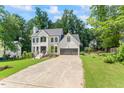 Gorgeous two-story home with a gray garage, well manicured yard and black trimmed windows at 4408 Queenstown Ct, Raleigh, NC 27612