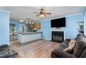 Open-concept living room featuring a fireplace, TV, wood floors, and bar connecting to the kitchen at 4575 Wendell Blvd, Wendell, NC 27591