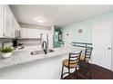 Open kitchen with breakfast bar features granite counters, stainless faucet, and updated appliances at 46 Sparger Springs Ln, Durham, NC 27705