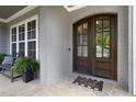 Beautiful double front doors with glass inserts, complemented by a stone porch and potted plants at 5100 Schellinger, Raleigh, NC 27612