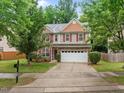 Beautiful two-story home with red shutters, stone accents and a large driveway at 552 Stobhill Ln, Holly Springs, NC 27540