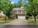 Inviting two-story home with red shutters, a stone facade and a lovely front lawn at 552 Stobhill Ln, Holly Springs, NC 27540