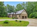 Inviting brick home featuring an attached two-car garage, manicured lawn, and a spacious circular driveway at 6617 Whitted Rd, Fuquay Varina, NC 27526