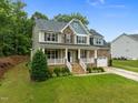 Charming two-story home with a welcoming front porch, manicured lawn, and attached two-car garage in a lovely community at 6949 Rex Rd, Holly Springs, NC 27540