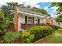 Beautifully landscaped home with brick accents, a cozy front porch, and lush greenery at 729 Mial St, Raleigh, NC 27608