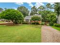 Well-manicured front yard featuring lush green grass, mature trees, and a charming stone walkway at 729 Mial St, Raleigh, NC 27608