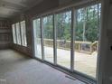 Spacious room featuring sliding doors leading to a new wooden deck overlooking a wooded area at 79 Oldham Estate Dr, Chapel Hill, NC 27517