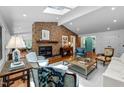 Bright living room featuring a brick fireplace, skylights, and hardwood flooring at 800 Shady Lawn Rd, Chapel Hill, NC 27514