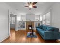 Cozy living room featuring a decorative fireplace and hardwood flooring, filled with natural light from large windows at 803 W Club Blvd, Durham, NC 27701