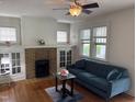 Cozy living room with a brick fireplace, hardwood floors, and natural light at 803 W Club Blvd, Durham, NC 27701