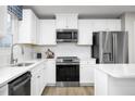 Bright kitchen featuring white cabinets, stainless steel appliances, and quartz countertops at 84 Saintsbury Dr, Fuquay Varina, NC 27526