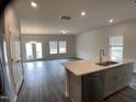 Bright kitchen and living space with gray cabinets, stainless appliances, and open floor plan at 909 Clearhaven Ln # 909, Fuquay Varina, NC 27526