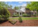 Beautiful brick home with mature landscaping, a cozy sunroom, and a well-maintained lawn at 102 Mel Oak Dr, Chapel Hill, NC 27516
