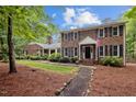 Charming brick home with black shutters, an American flag, and a well-manicured lawn at 102 Mel Oak Dr, Chapel Hill, NC 27516