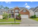 Traditional brick home featuring a well-maintained lawn, attached garage, and covered front entry at 106 Elmsford St, Durham, NC 27703