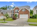 Charming brick home with an attached two-car garage and lush green lawn at 106 Elmsford St, Durham, NC 27703