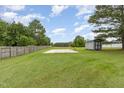 Spacious backyard featuring a basketball court, storage shed, wooden fence and mature trees at 109 D A King Dr, Willow Springs, NC 27592