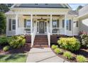 Inviting front porch with classic columns, brick steps, and lush landscaping, a warm welcome at 113 Cedardale Ct, Clayton, NC 27520