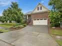 Well-maintained home with a brick facade, two-car garage, and established landscaping at 136 Shadow Hawk Dr, Durham, NC 27713