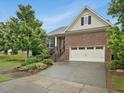Attractive brick home with an attached garage, landscaped front yard, and inviting curb appeal at 136 Shadow Hawk Dr, Durham, NC 27713
