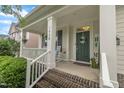 Inviting front porch with brick steps, white columns, and a charming green front door at 1920 Bright Kannon Way, Wendell, NC 27591