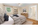Comfortable bedroom features a ceiling fan, plush bedding, and hardwood floors at 2015 Walnut St, Durham, NC 27705