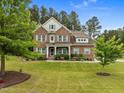 A well-maintained brick home set on a spacious lawn with mature trees, offering a picturesque curb appeal at 21 Botanical Way, Pittsboro, NC 27312