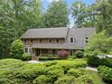 Well-maintained brick home surrounded by lush greenery, creating a private setting at 2300 Valley Forge Dr, Raleigh, NC 27615