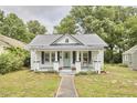 Quaint home with a well-kept lawn and a covered front porch, perfect for enjoying the outdoors at 2418 Highland Ave, Durham, NC 27704