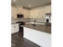 Modern kitchen featuring white cabinets, stainless steel appliances, and a granite countertop island at 269 Hank Way, Angier, NC 27501
