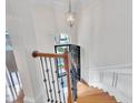 Bright foyer showcases an elegant staircase with wood treads and iron railings and designer lighting at 2744 Laurelcherry St, Raleigh, NC 27612