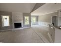 Spacious living room featuring a fireplace, vaulted ceiling, and large windows at 2744 Rains Mill Rd, Princeton, NC 27569