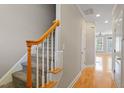 View of staircase leading into a spacious hall with doors and wood flooring at 2822 Pickett Rd # 132, Durham, NC 27705