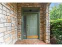 Charming front door with stone surround, brass accents, and sidelight providing a warm and inviting entrance at 301 Presque Isle Ln, Chapel Hill, NC 27514