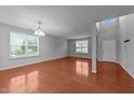 Bright living room with hardwood floors, neutral paint, large window, and an open floor plan at 3705 Rivermist Dr, Raleigh, NC 27610