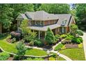 Aerial view of a grand brick home with lush landscaping, mature trees, and a well-maintained lawn at 4021 Chaumont Dr, Apex, NC 27539