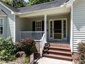 Close-up of the front porch, showing the house number, and a white picket fence, with brick steps at 4132 Battle Field Dr, Garner, NC 27529